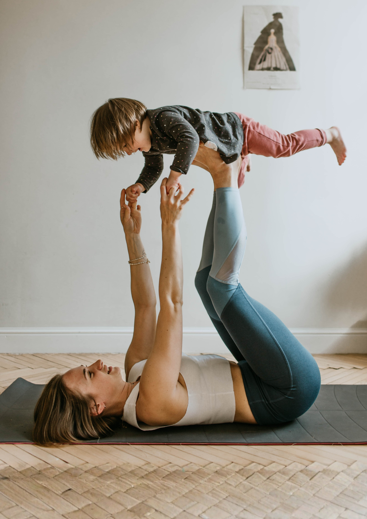 A child balances on their mother's legs