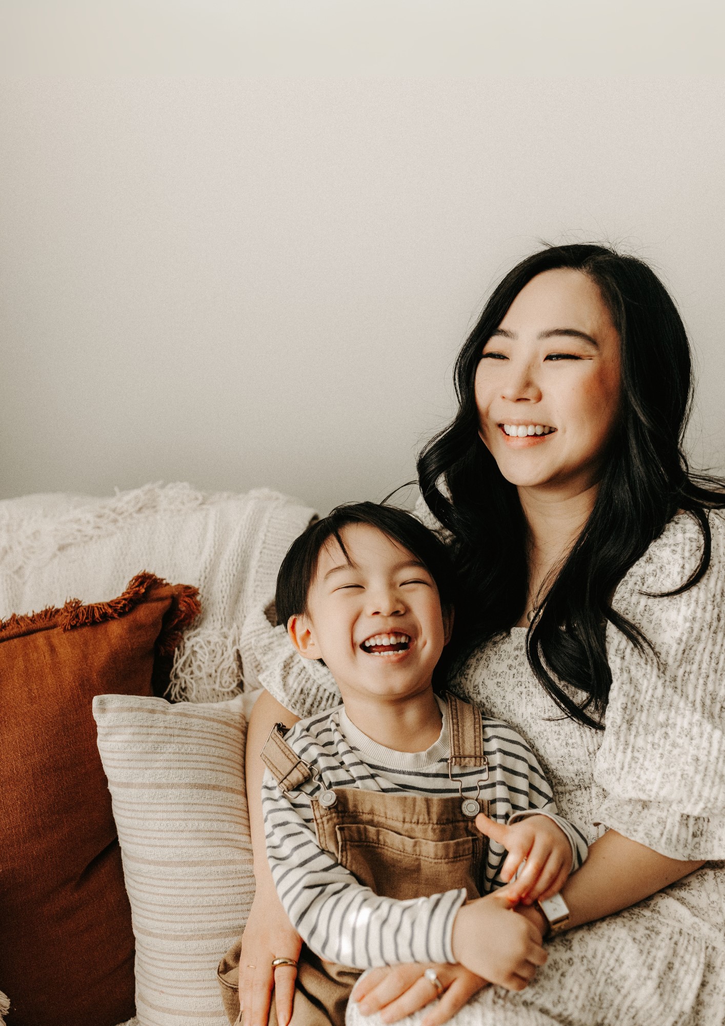A mother and child cuddle on a sofa.