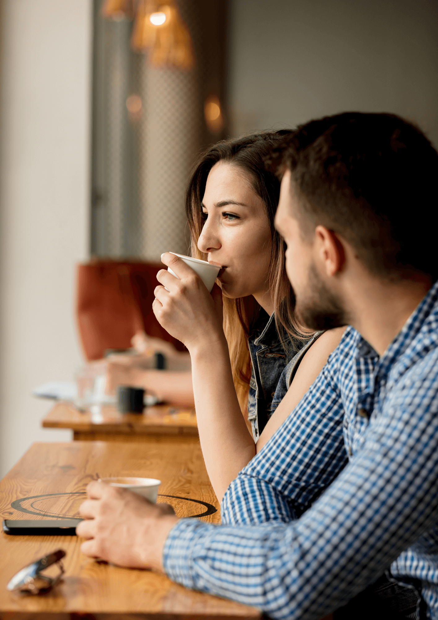 A white woman and man sitting together and drinking coffee
