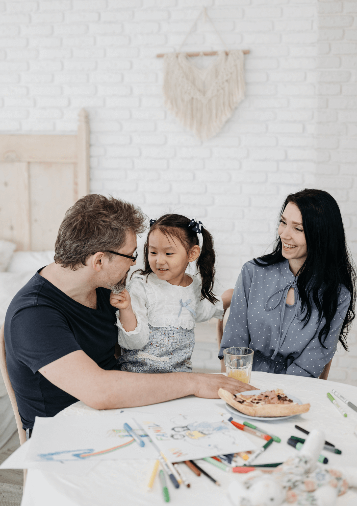 A father and mother interacting with their young daughter