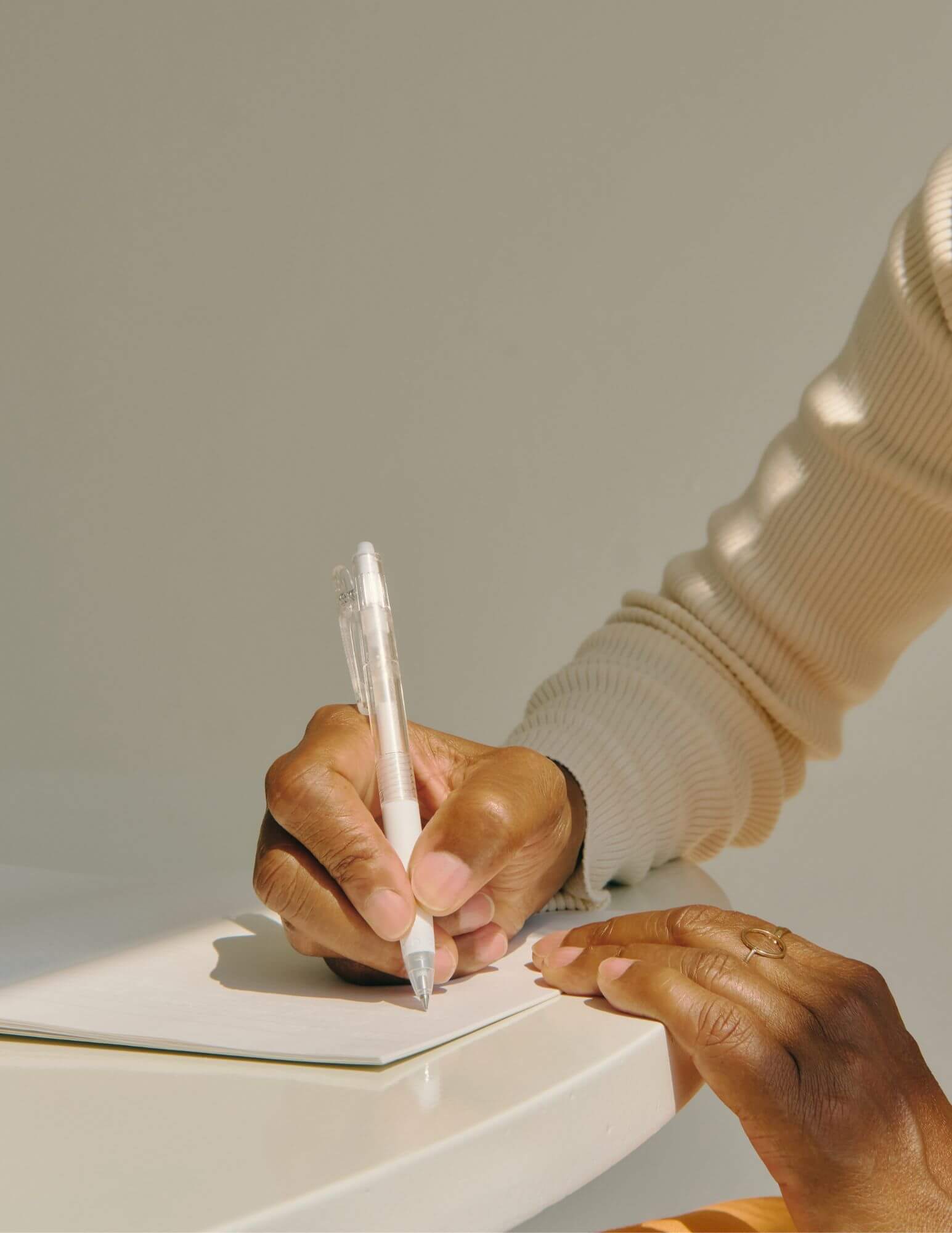 A person's hands writing notes in a notebook