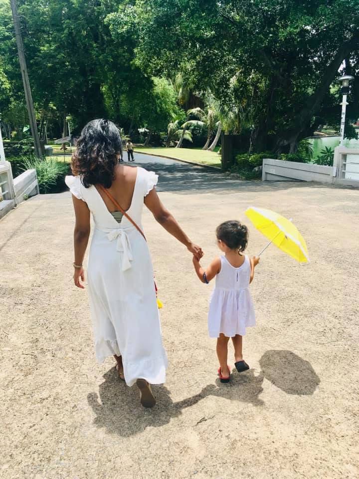 A mother and daughter walk away from the camera