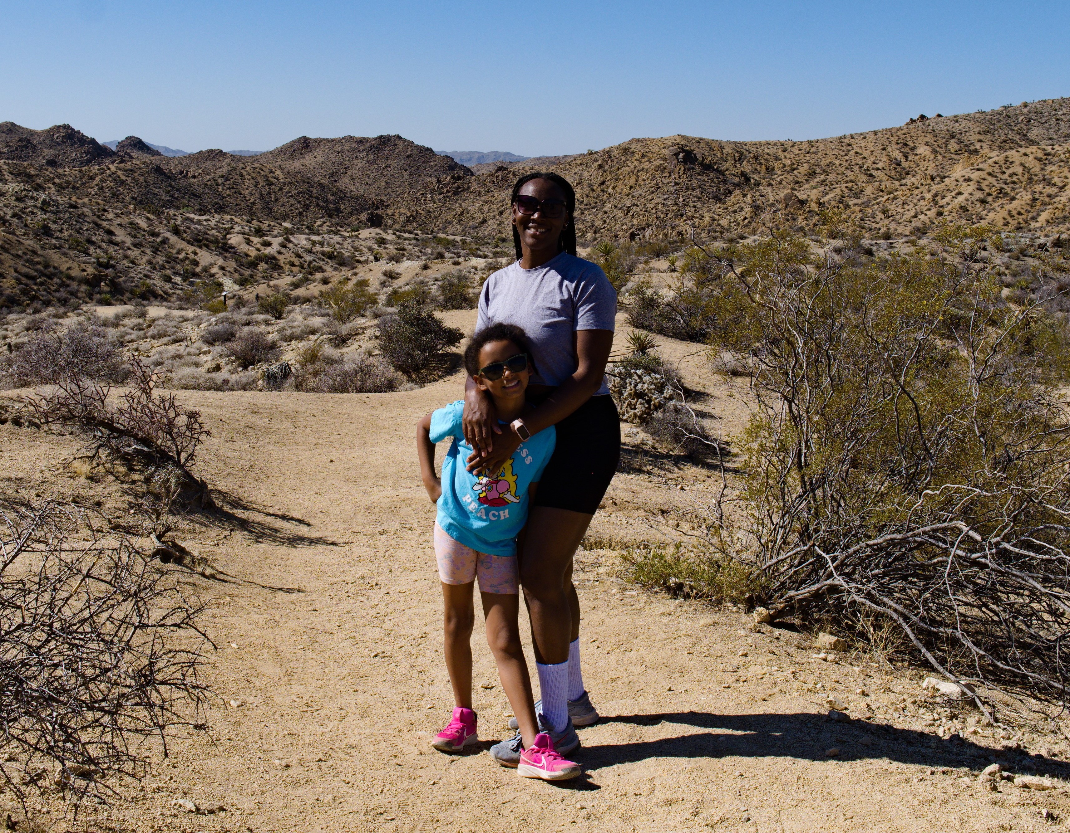 A mother and daughter walk in a desert national park.