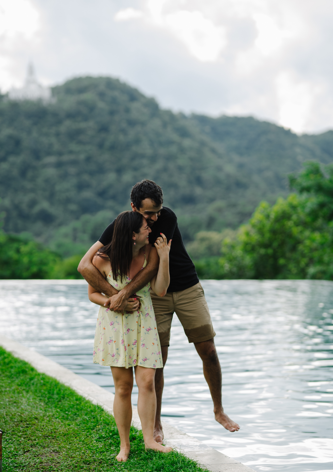 A man and woman hug on a river bank