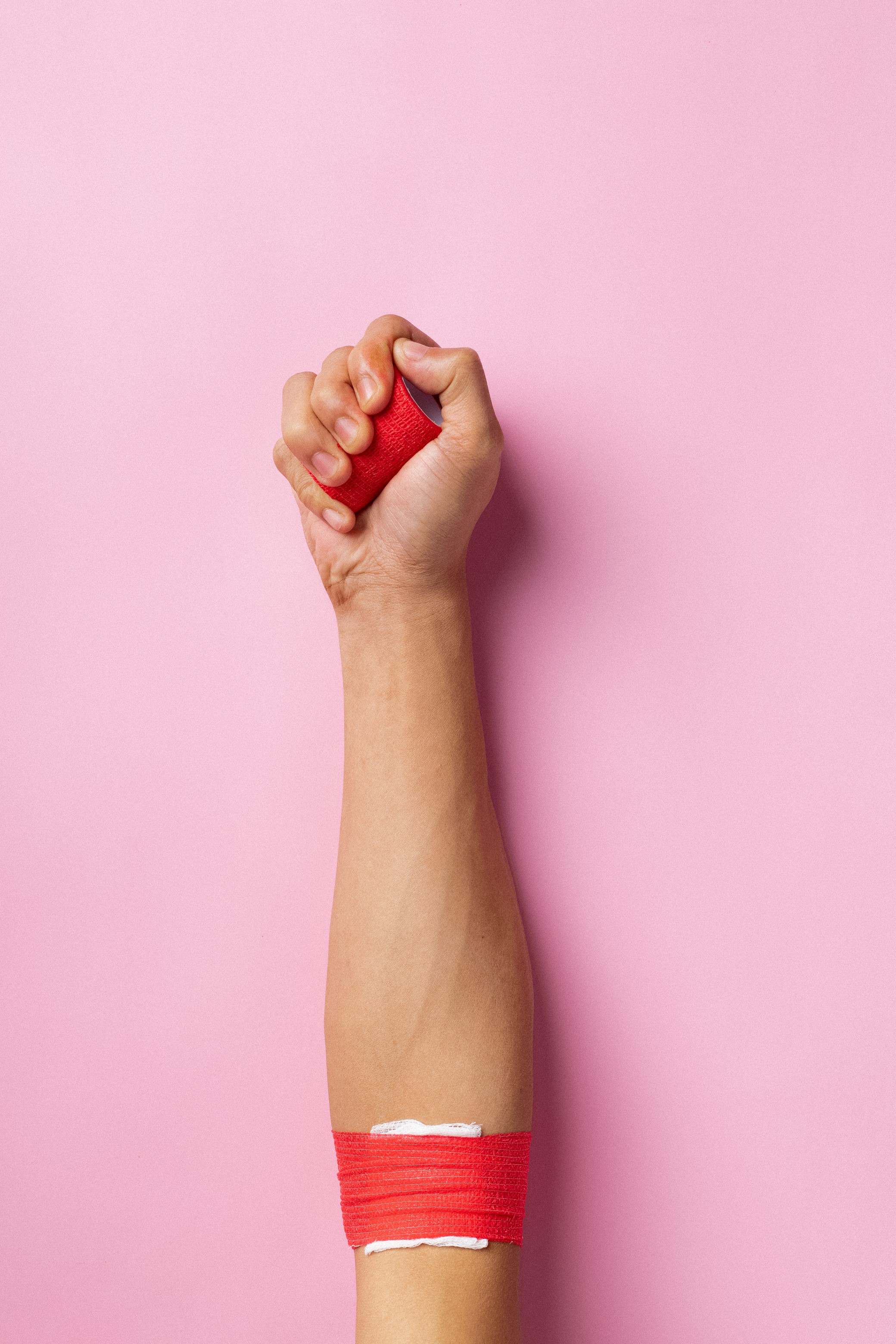 A hand and arm on a pink background.