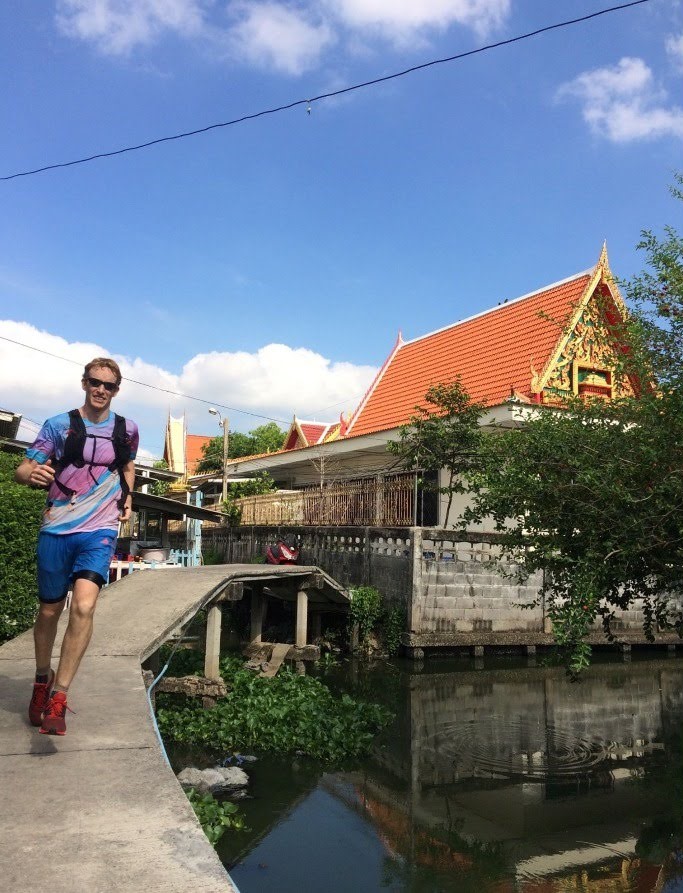 A white man running alongside a waterway in Bangkok, Thailand
