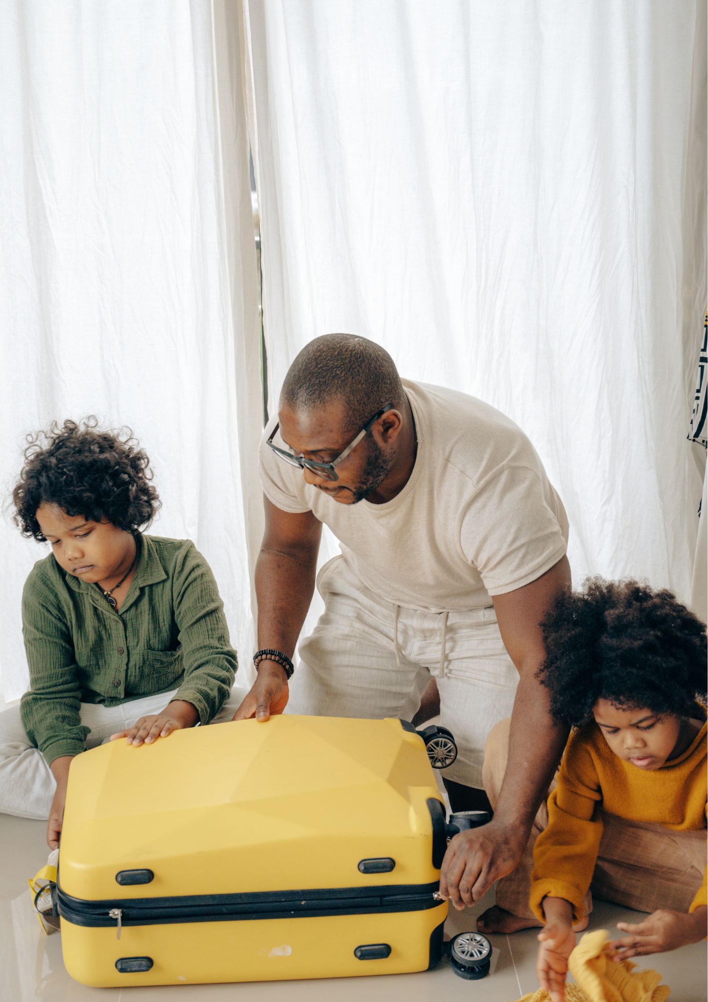 A father and two children try to shut a suitcase