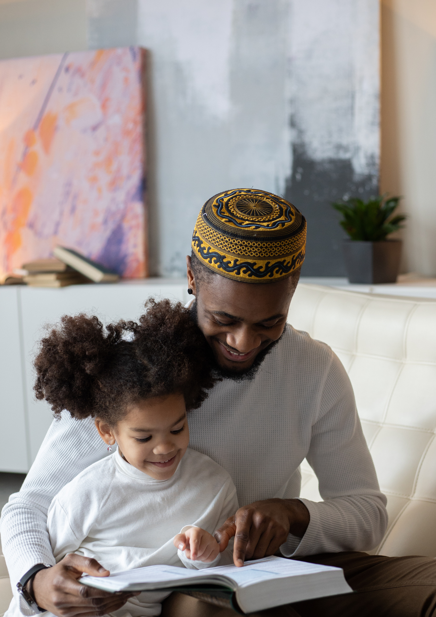 A Black father and his daughter read together