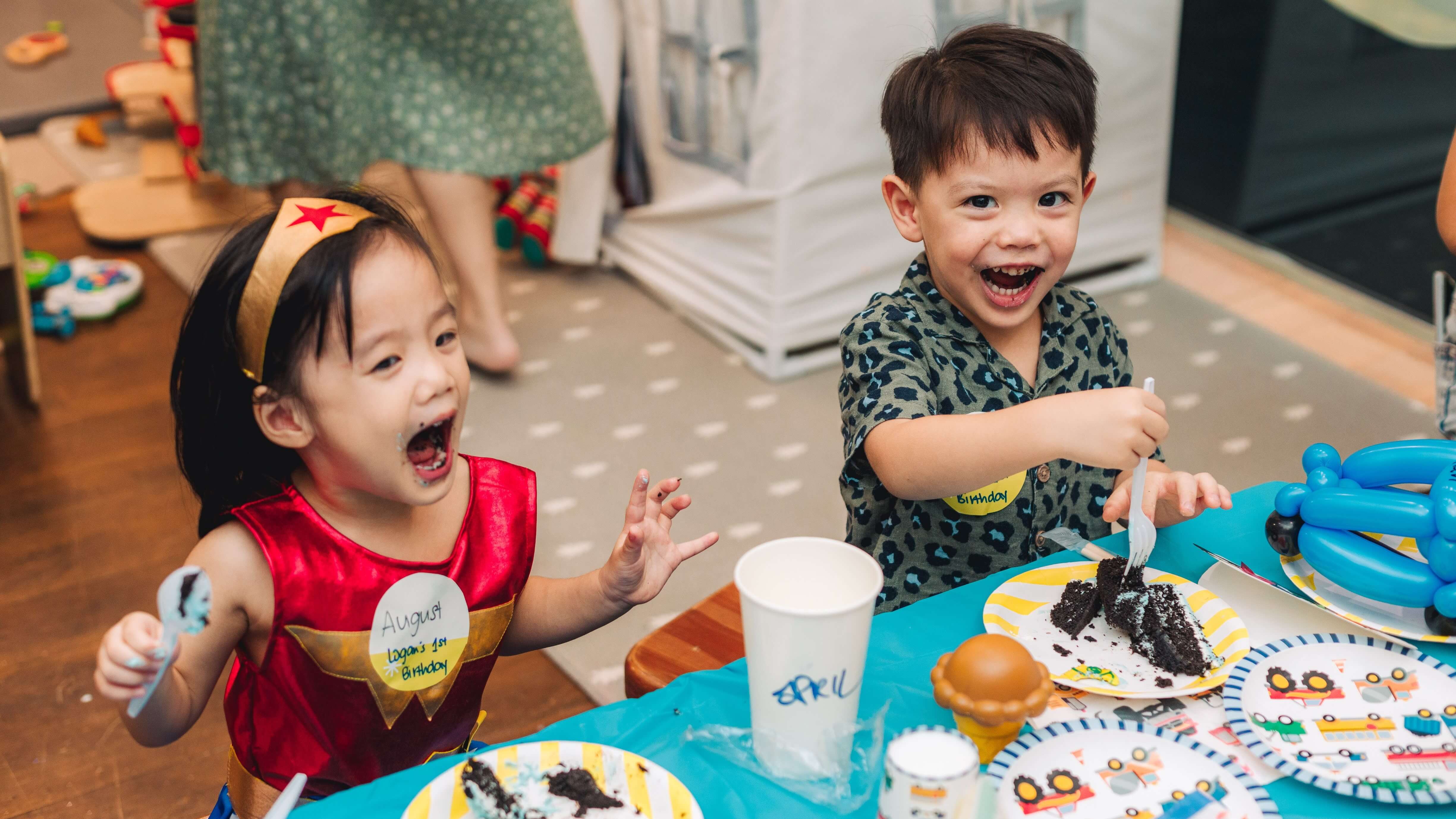 Two toddlers at a birthday party eating cake