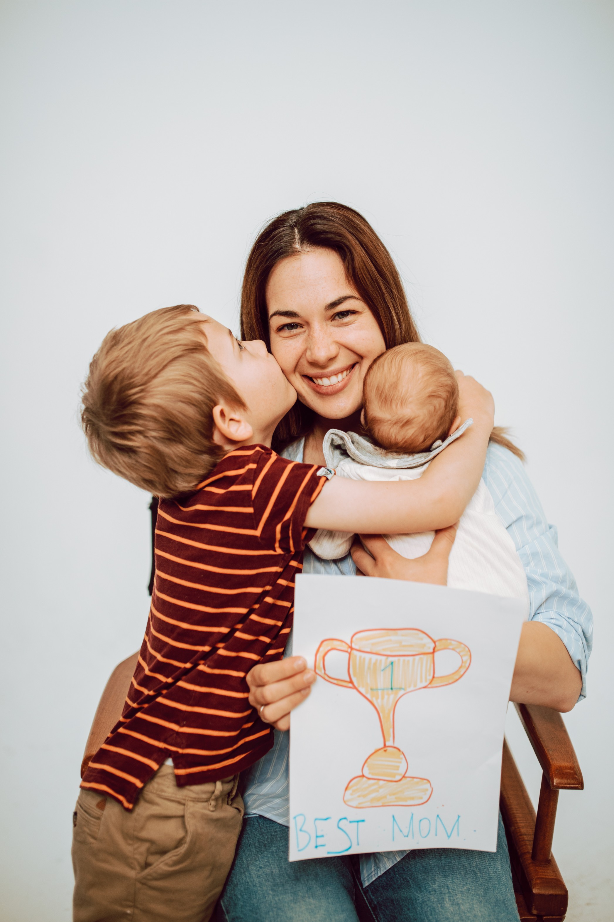 A mother hugs her two children