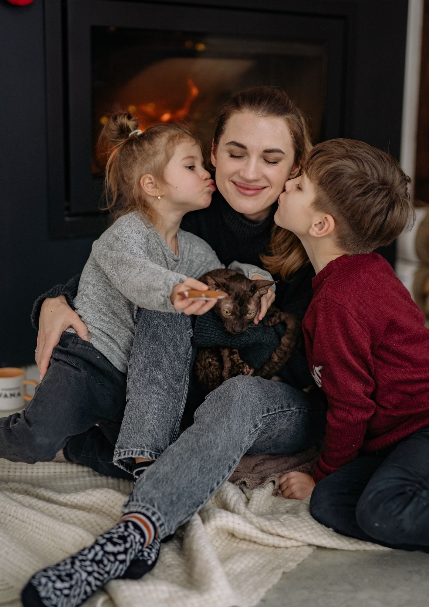 Two kids kiss their mother