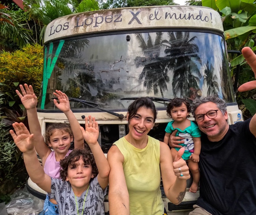 Latino family infront of bus, waving