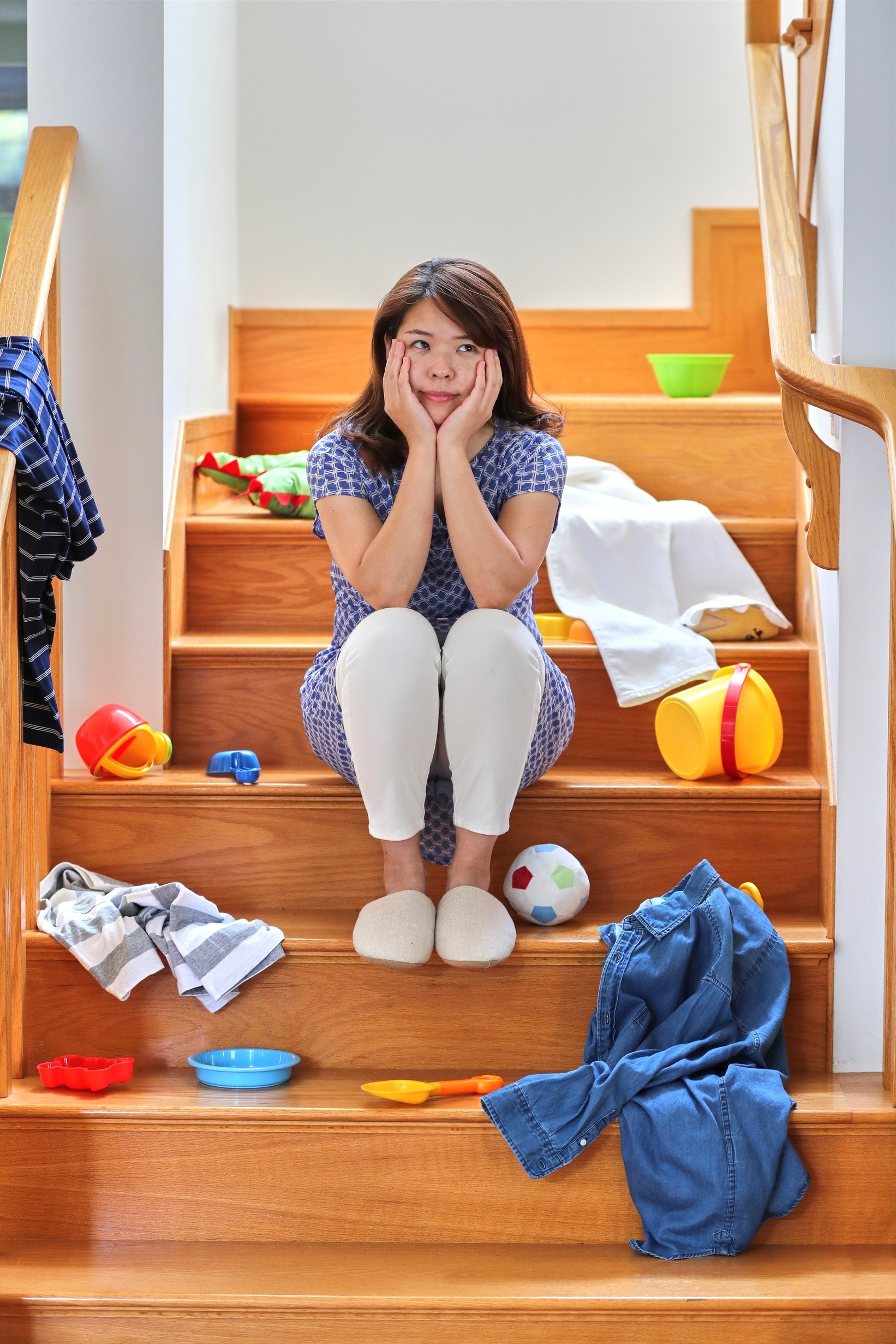 A lady sits on a messy staircase