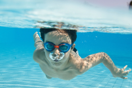 A child swimming underwater in a pool