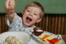 A child smiles happily over a full table