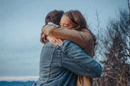A couple hug outside