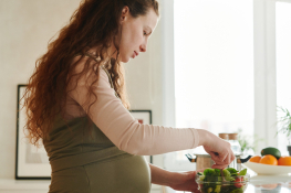 A pregnant woman makes a salad