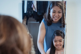 A mother and daughter look in a mirror
