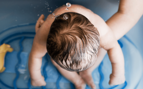 A baby in the bath from a bird's-eye position
