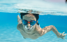 A child swimming underwater in a pool