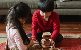 Two Asian children playing JENGA