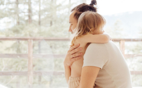 A parent hugging their toddler