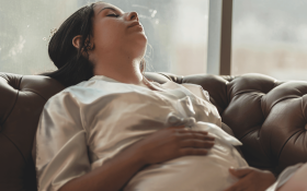 A lady sleeps on a couch.