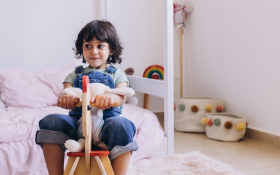 A child sits on a rocking horse.