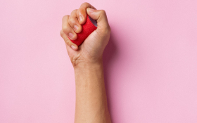 A hand and arm on a pink background.