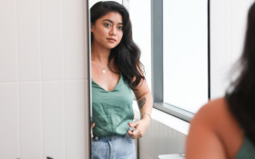 A woman looks at herself in the mirror.