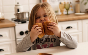 A child tears into a bagel.