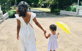 A mother and daughter walk away from the camera.