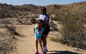 A mother and daughter walk in a desert national park.