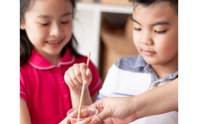 Two children mix paint.