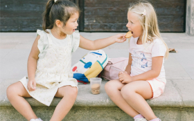 Two girls sit on a step